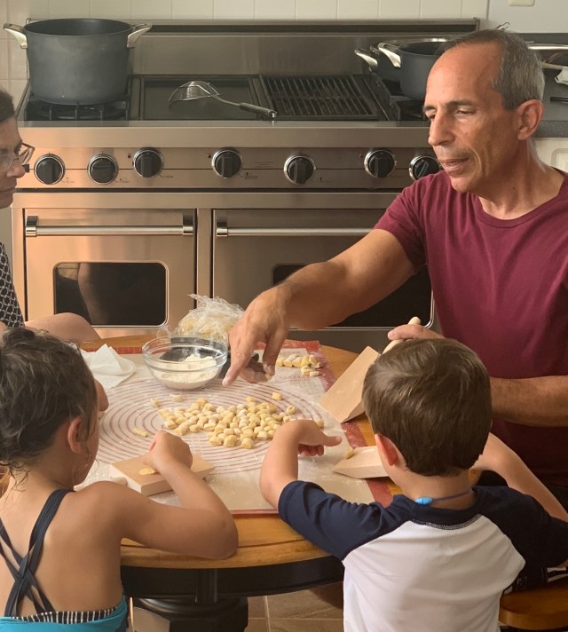 Sitting in my kitchen showing two children how to make pasta.